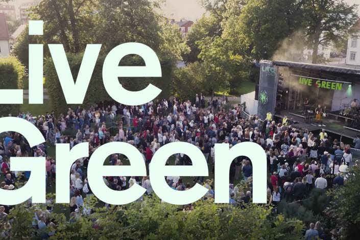 Text med LiveGreen, i bakgrunden en utomhusscen med publik.