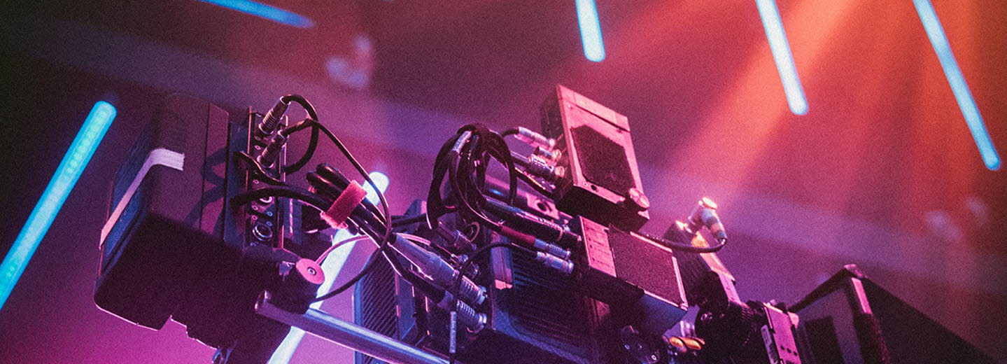 Omslag i lila-rosa toner med en filmkamera. 