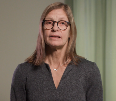 Kvinna framför vägg.