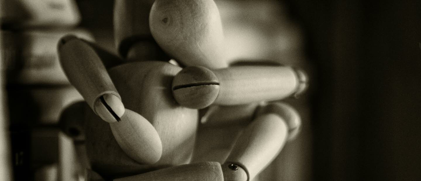 Två människomodeller i trä kramas. 