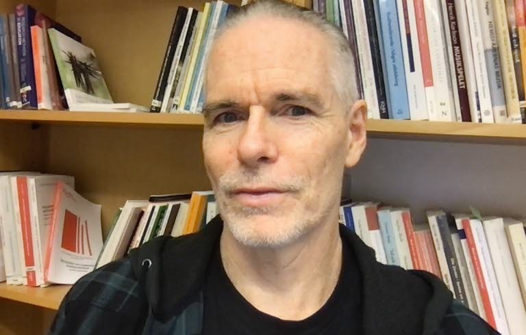 Ketil Thorgersen framför bokhyllor.