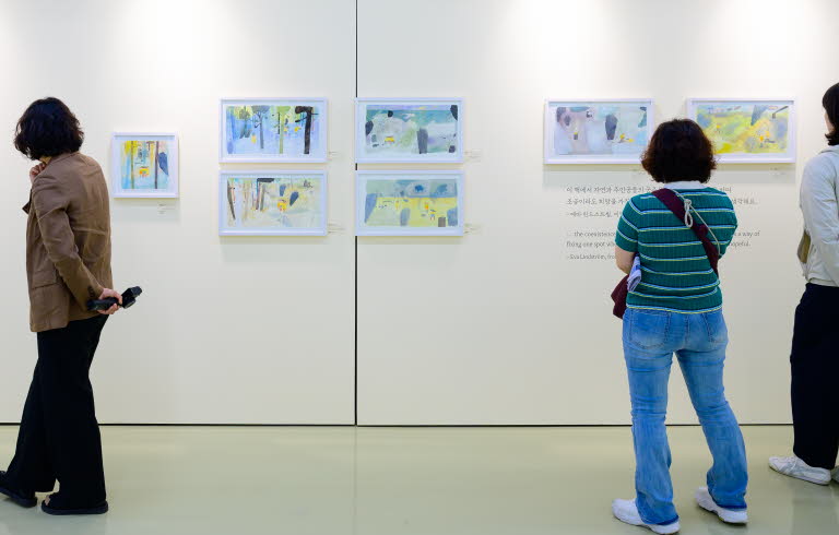 Tre personer tittar på en utställning med teckningar av Eva Lindström under Jeonju internationella bilderboksmässa 2025. Three people are viewing an exhibition of drawings by Eva Lindström at the Jeonju International Picture Book Fair 2025.