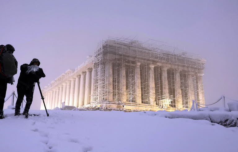 Två fotografer dokumenterar stor byggnad i snöstorm.Bild: Stavros Petropoulos /Alaska for Onassis Foundation.