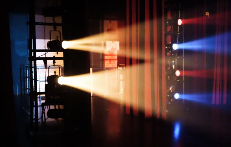 Scen belyst med gult, blått och rött ljus.