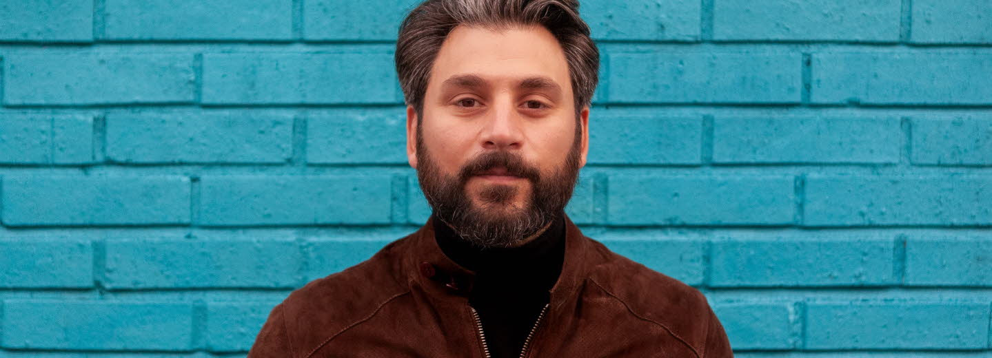 Fotografi av Daniel Boyacioglu mot en blå bakgrund