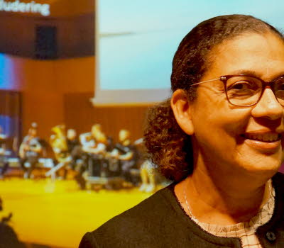 Bild på Sophia Alexandersson, med en orkester i bakgrunden. 