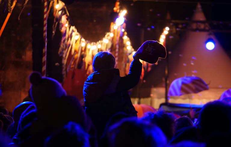 Publik framför en scen i dunkel lila beslysning.