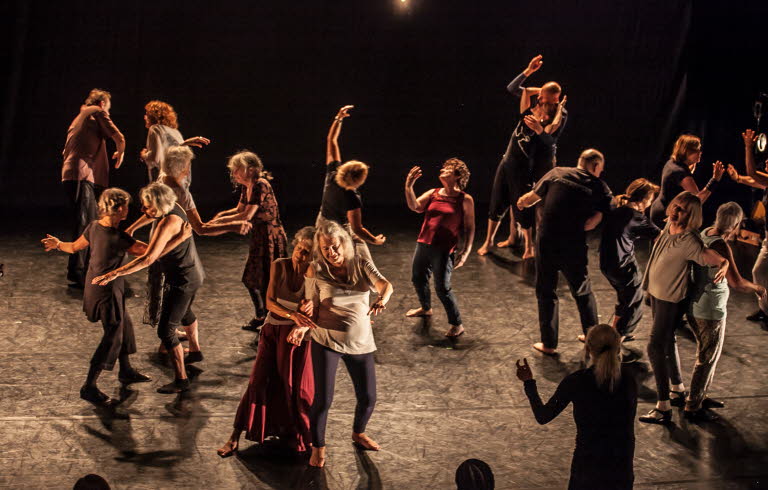 Äldre människor dansar tillsammans på en scen.