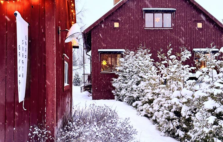 Två röda hus i vinterlandskap.