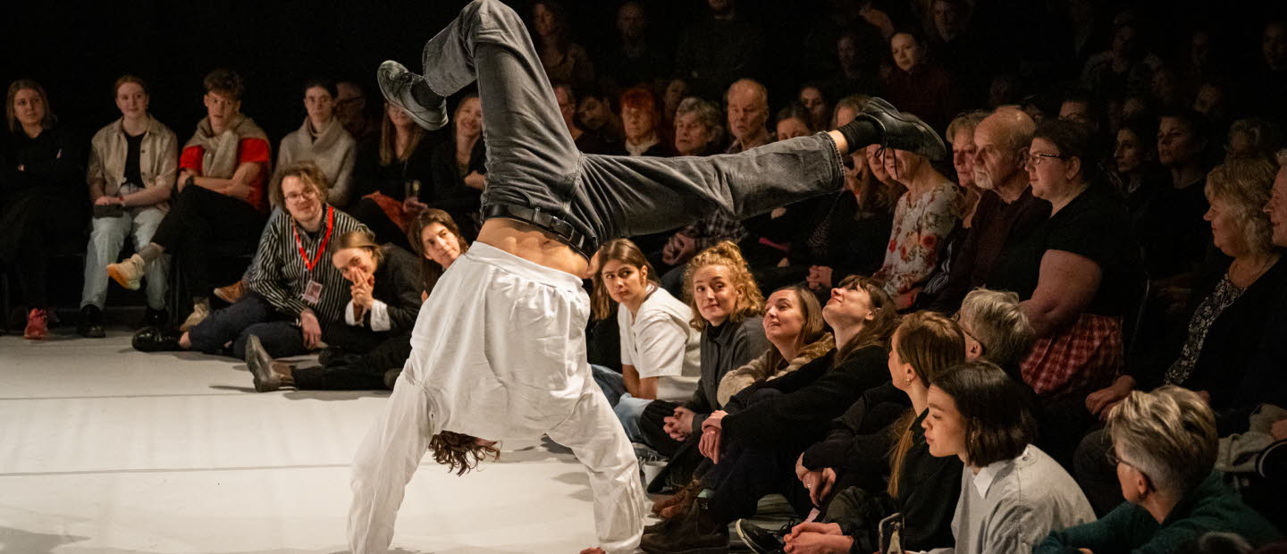 Kille står på händer inför en publik.