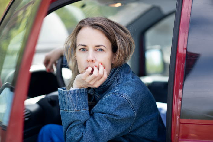 Portrait of Annika Norling sitting in a red car. 