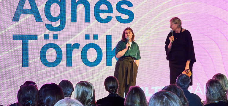 Två personer samtalar på en scen.