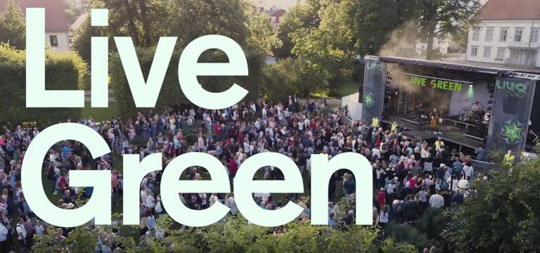 Text med LiveGreen, i bakgrunden en utomhusscen med publik.