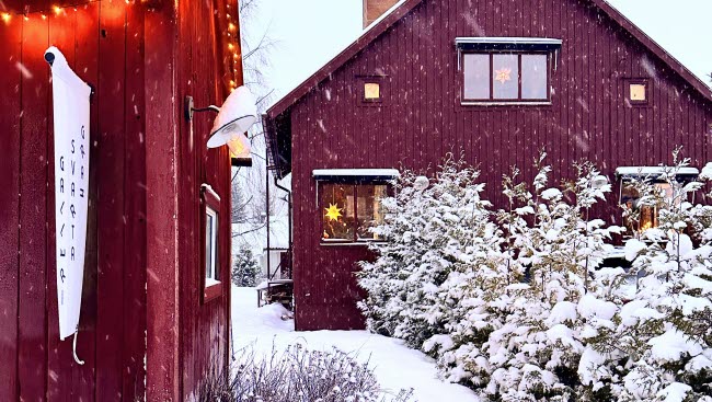 Två röda hus i vinterlandskap.