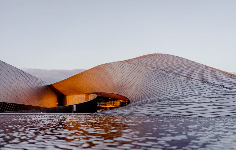 Böljande byggnad som ser ut som en sandbänk.