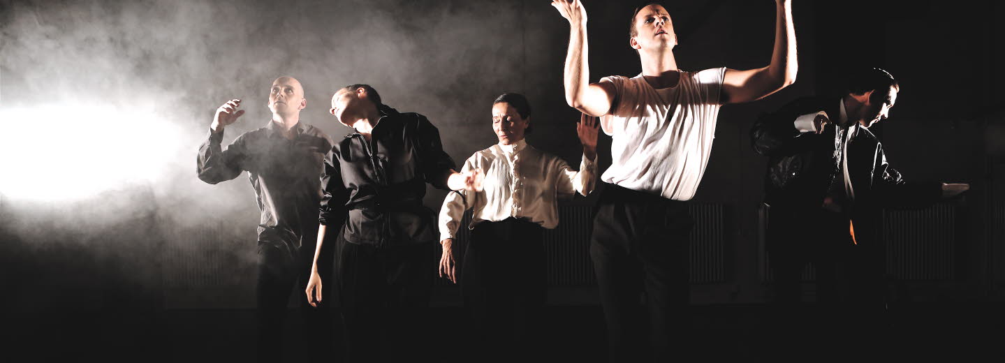 Föreställningsbild Rivers of Färila. Manliga skådepselare i dans, svart bakgrund och rök. 