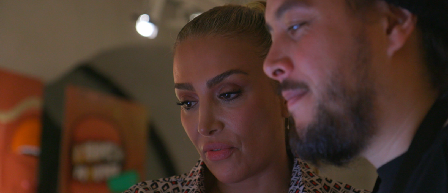 Närbild av en kvinna och en man som tittar ner på något utanför bilden.