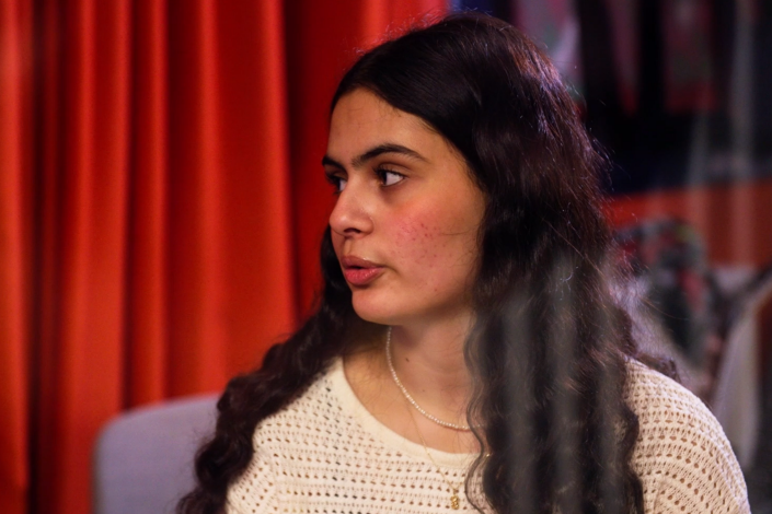 En kvinna som står framför ett draperi.