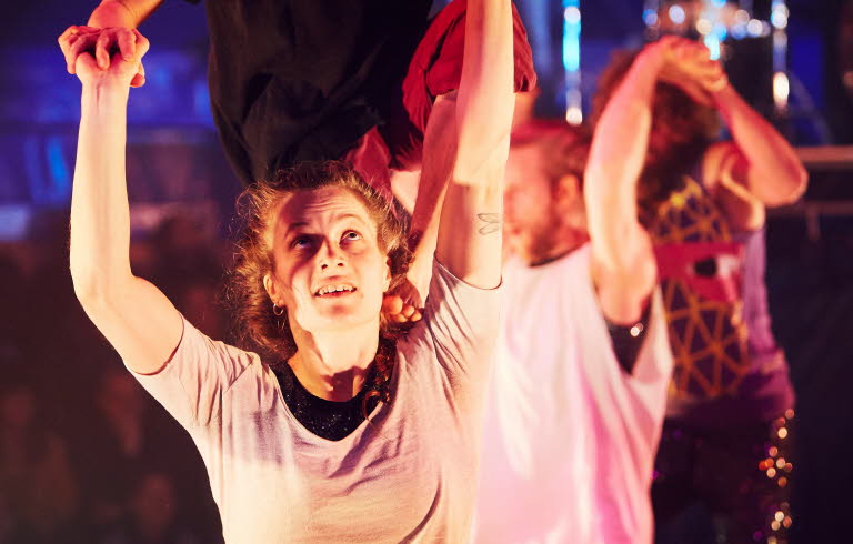 En grupp män och kvinnor som utför akrobatik.