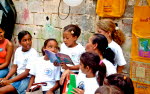Flicka läser en bok omgiven av andra barn