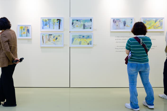 Tre personer tittar på en utställning med teckningar av Eva Lindström under Jeonju internationella bilderboksmässa 2025. Three people are viewing an exhibition of drawings by Eva Lindström at the Jeonju International Picture Book Fair 2025.