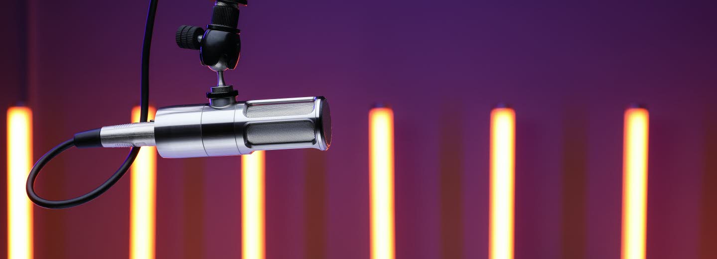 Foto på mikrofon. Smala ljuspelare i bakgrunden.