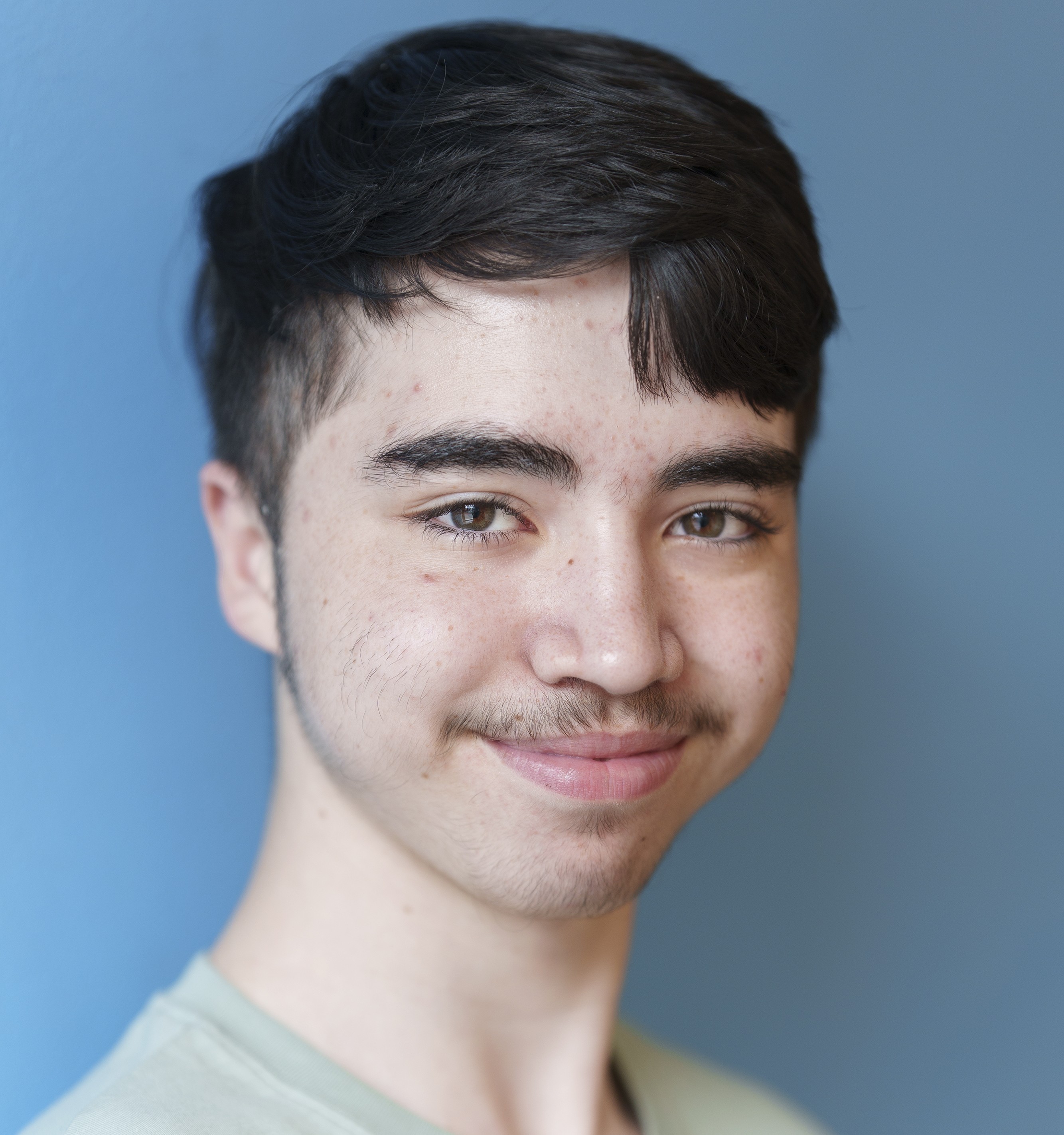 Leende ung kille med kort m&ouml;rkt h&aring;r.