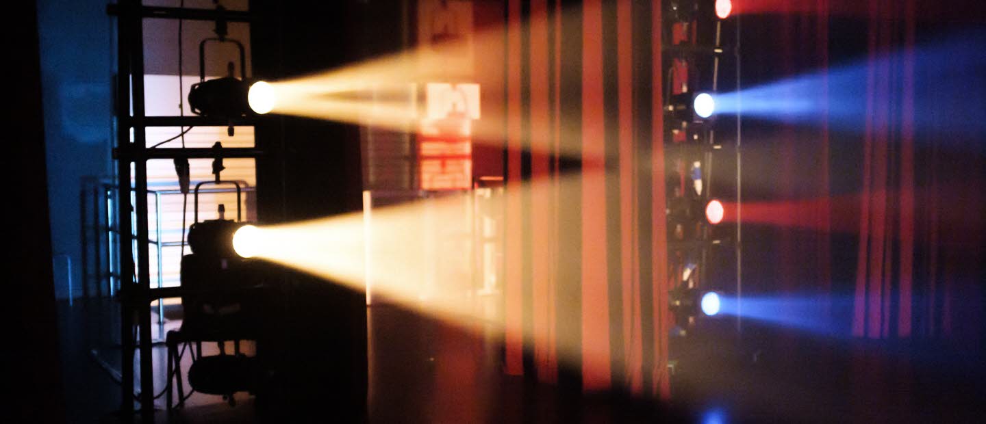 Scen belyst med gult, blått och rött ljus.