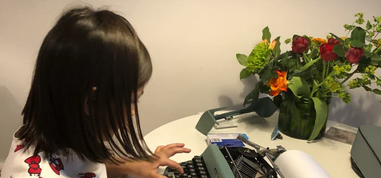 Ett barn skriver på en skrivmaskin