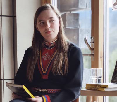 Kvinna samtalar vid fönster.