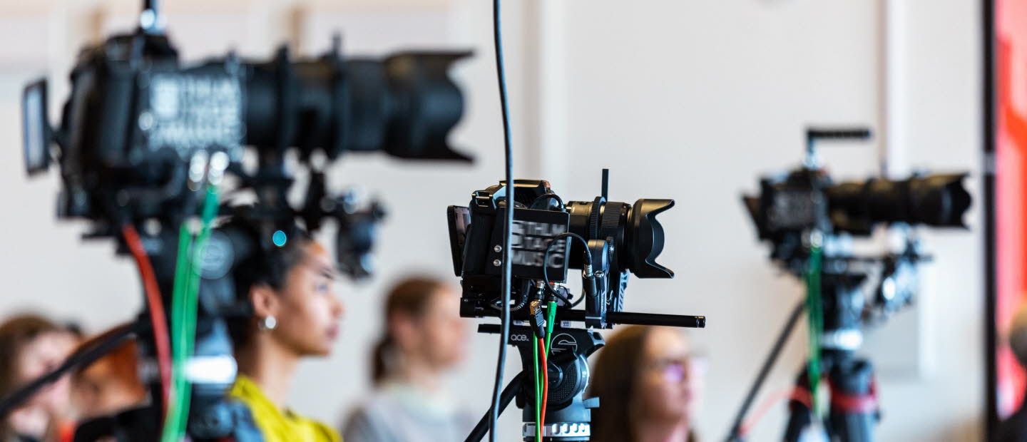 Tre filmkameror på stativ.