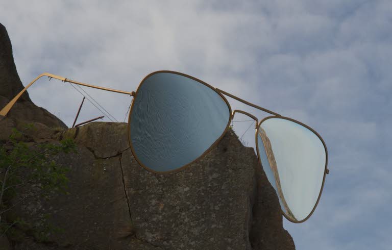 Ett konstverk, i form av ett par glasögon, på en klippa.