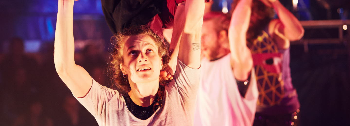 En grupp män och kvinnor som utför akrobatik.