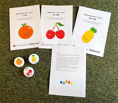 Foldrar och pins med glada frukter från projektet 1000 böcker för F-klass.