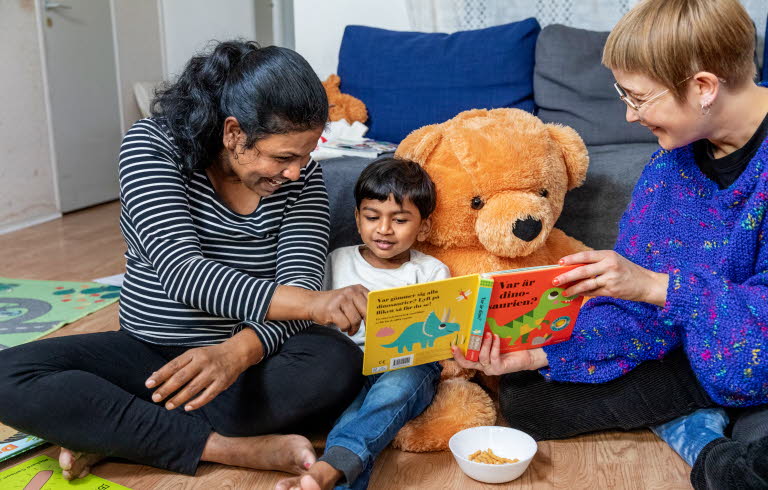 Barn som läser tillsammans med vuxna under ett Bokstartsbesök. Foto: Susanne Kronholm