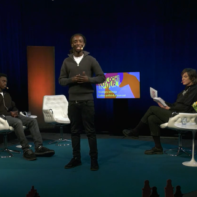 En kille står i en studio och läser poesi.