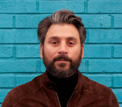 Fotografi av Daniel Boyacioglu mot en blå bakgrund