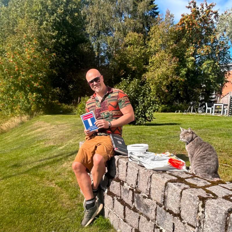 Tommy Bildström sitter på en mur.