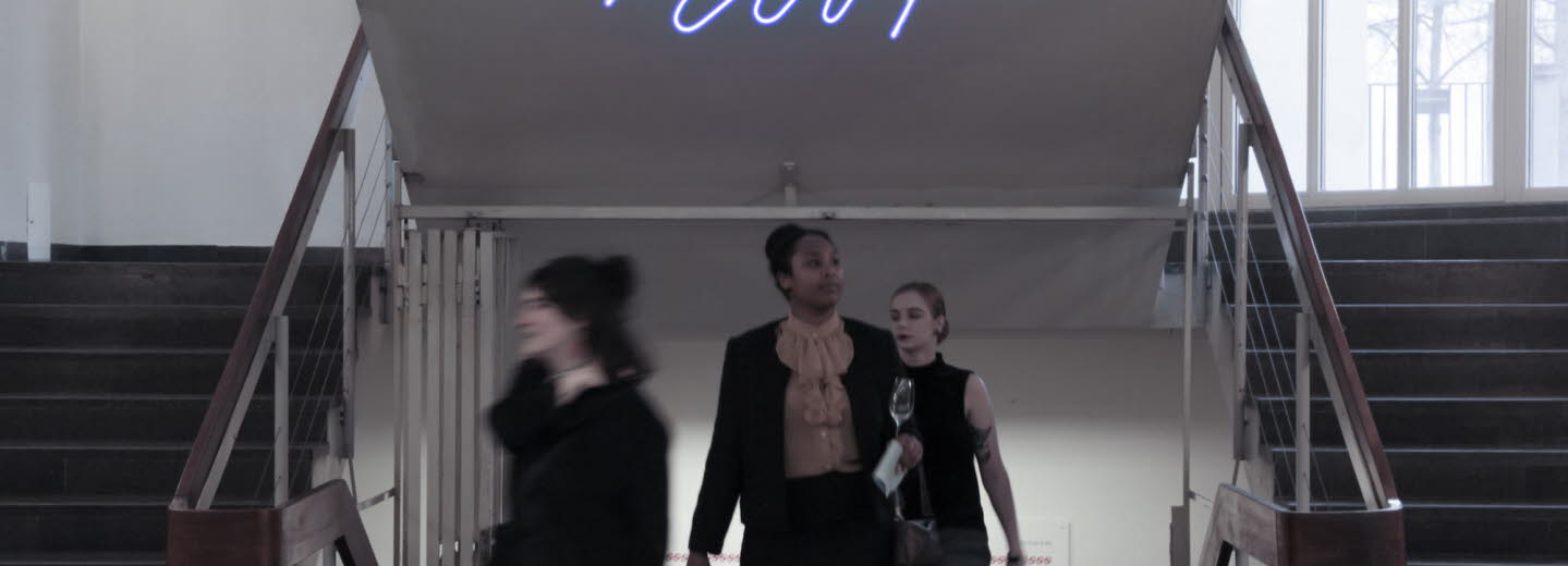 Människor är på väg uppför en trappa. Ovanför står det "Mint" i neon.