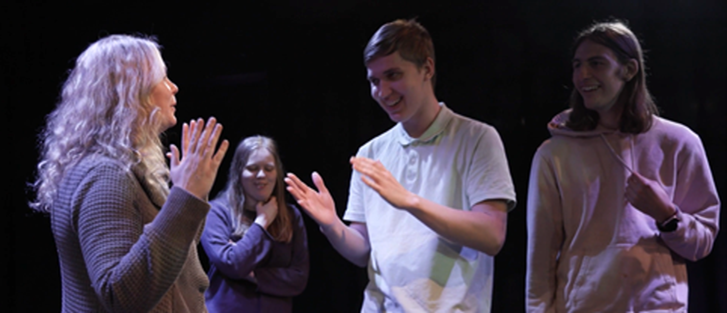 Fyra personer agerar på en scen. 