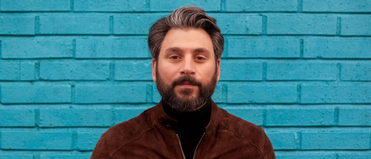 Fotografi av Daniel Boyacioglu mot en blå bakgrund