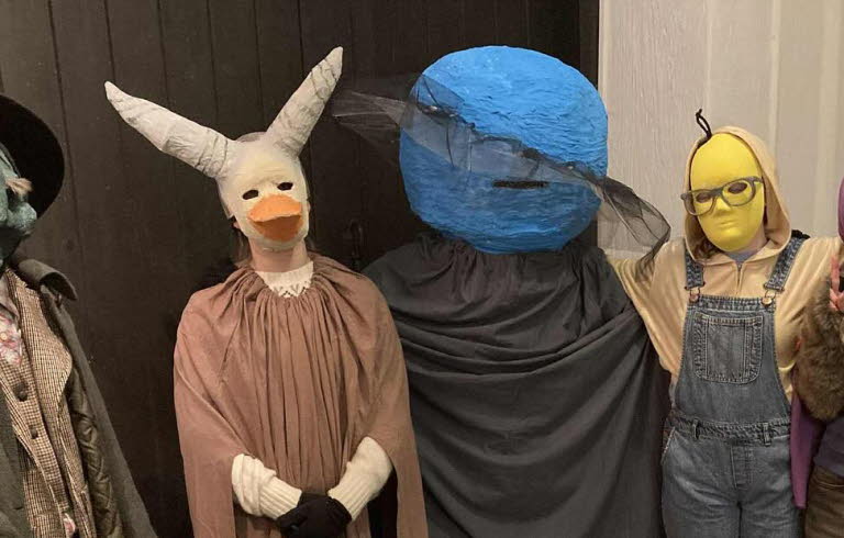 Fem undomar i masker och kostymer.
