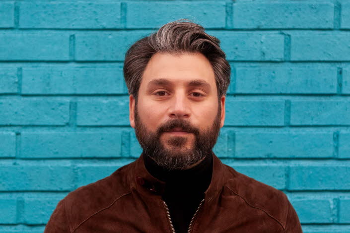 Fotografi av Daniel Boyacioglu mot en blå bakgrund