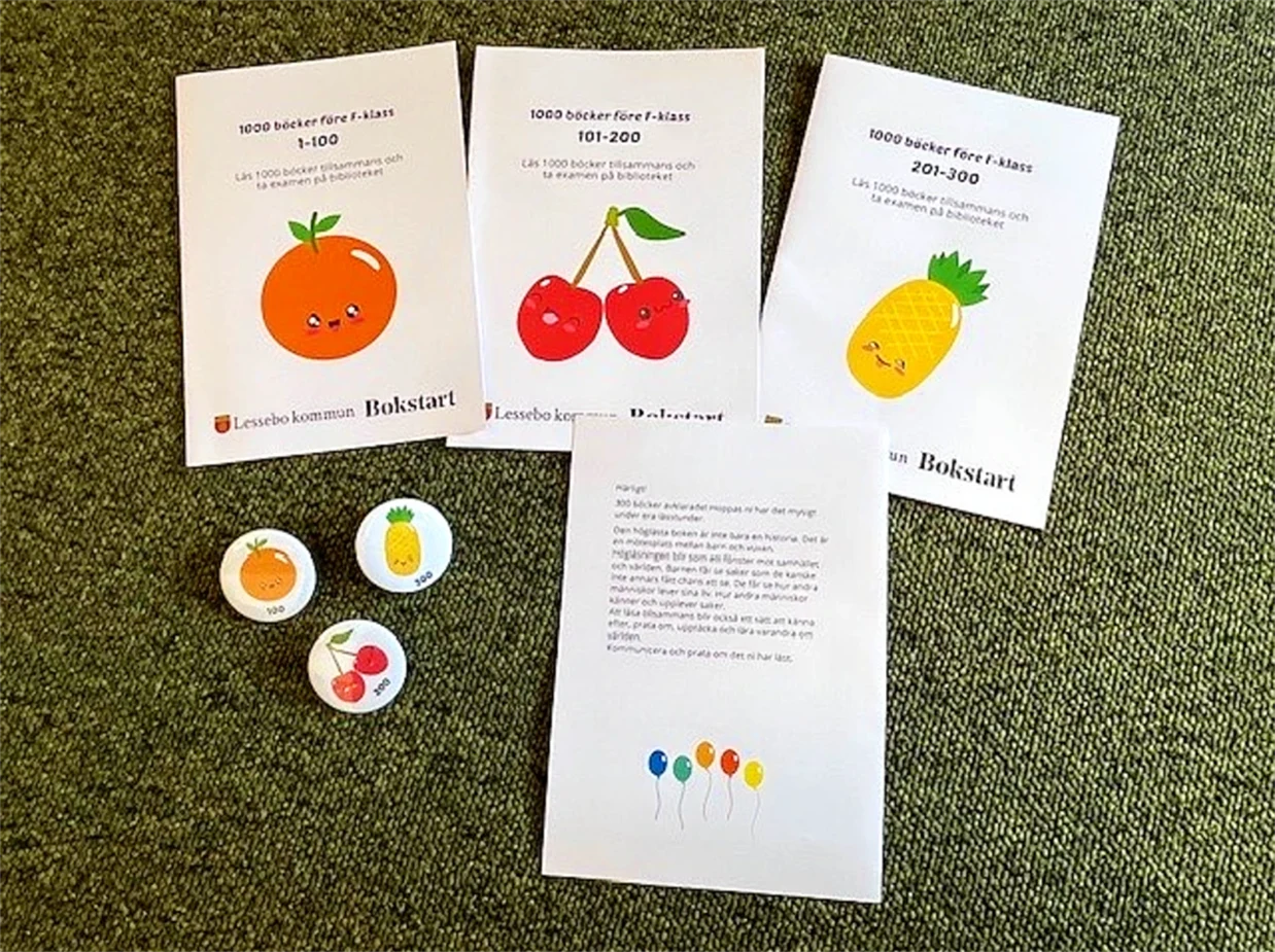 Foldrar och pins med glada frukter från projektet 1000 böcker för F-klass.