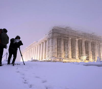 Två fotografer dokumenterar stor byggnad i snöstorm.Bild: Stavros Petropoulos /Alaska for Onassis Foundation.