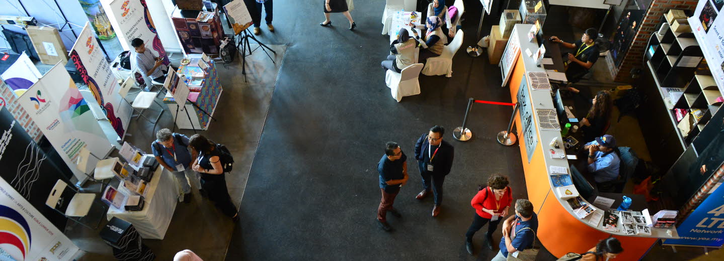 Foto taget ovanifrån på ett golv fyllt av människor och informationsbord.