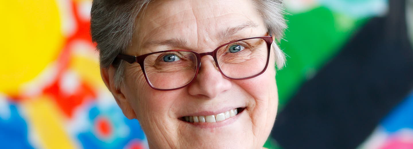 Maria Becker Gruvstedt fotograferad mot en färgglad bakgrund