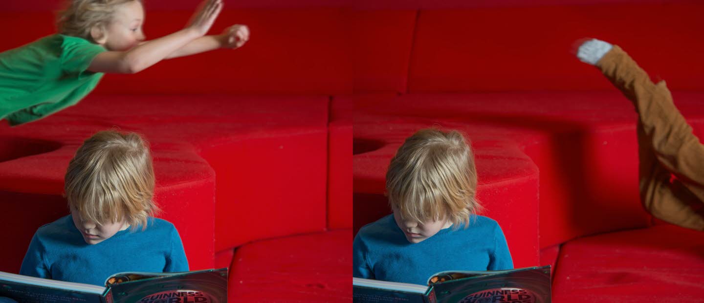 Ett läsande och ett flygande barn i bakgrunden