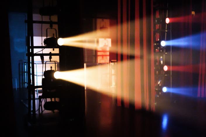 Scen belyst med gult, blått och rött ljus.