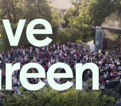 Text med LiveGreen, i bakgrunden en utomhusscen med publik.